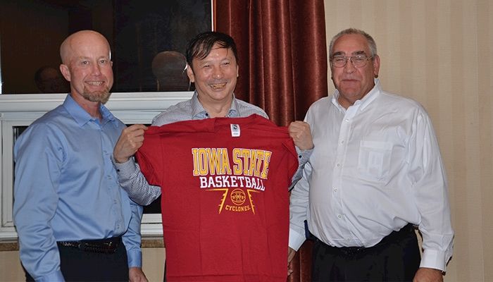Iowans Mark Kerndt and Dave Miller present Wang Hui Jun (an official with the agricultural university in Hebei, China) with an Iowa State University t-shirt.