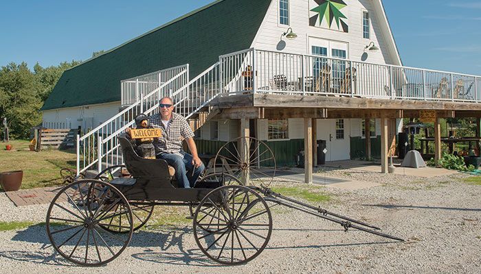 Max Steigleder sits on an old buggy that helps decorate North River Adventures near Carlisle. The Warren County Farm Bureau family offers event space, corn mazes and other ag-themed attractions.