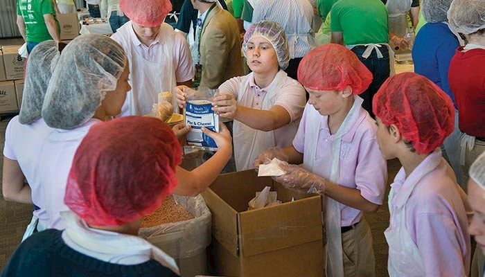 Students from St. Augustin Catholic School in Des Moines packaged meals during the Iowa Hunger Summit last month. The macaroni and cheese packets are donated to food banks across Iowa.