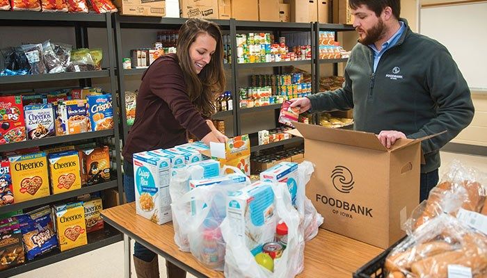 Cara Graziano, community school site coordinator for Des Moines Public Schools, and Danny Akright, communications manager for the Food Bank of Iowa in Des Moines, set up the new school food pantry last month at Lincoln High School. 