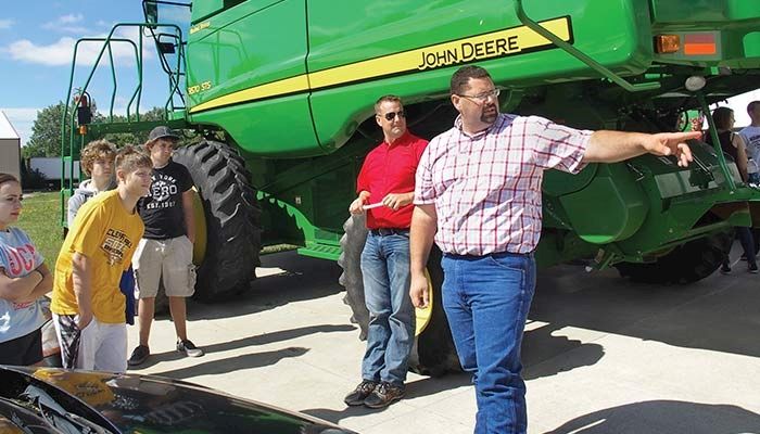 Cerro Gordo County Farm Bureau President Eric Arthur, second from right, and board member Kevin Pope, right, demonstrated how limited the road visibility is behind a combine.