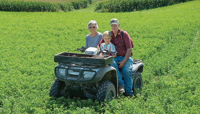 Dale and Karen Green, pictured with grandson John Melcher, farm near Castalia in Winneshiek County. 