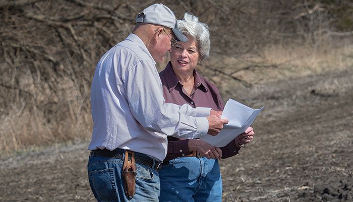 Polk County Farm Bureau members Randy and Carol Miller review the plans to install a bioreactor on their farm. The bioreactor removes nitrates from water flowing off fields.