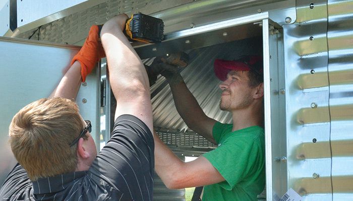 Matt Vegter, left, of the Polk County Farm Bureau works with Chipper Fyfe of GoServ Global