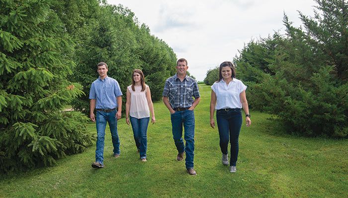 Bruce and Jenny Wessling, on the right, walk along a tree line with their daughter, Jolee, and her fiance, Austin Saddoris, on their Greene County farm near Grand Junction. 