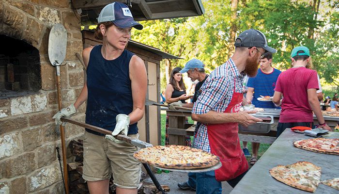 Rachel Slezak at Geyer's Oven near Oxford carries a fresh pizza out of the outdoor wood-fired pizza oven. 