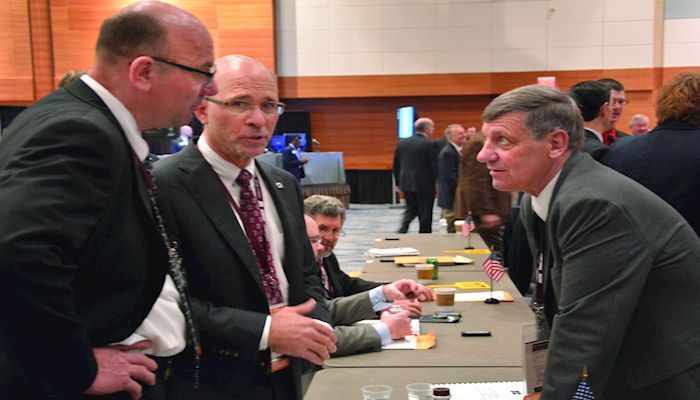 Iowa Farm Bureau delegates, Allen Burt of Marshall County, left, Don Swanson of Wapello County, center, and Terry Murray of Buena Vista County, prepare for the delegate session at the American Farm Bureau Federation annual policy session in Phoenix