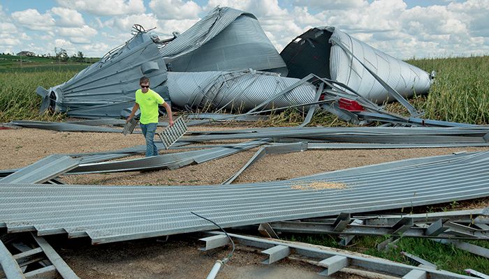 Nate Hofmann surveys grain bin damage, caused by Iowa derecho, on his farm in Jones County, Iowa