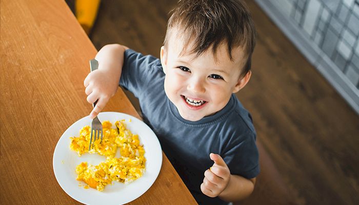 kid eating eggs