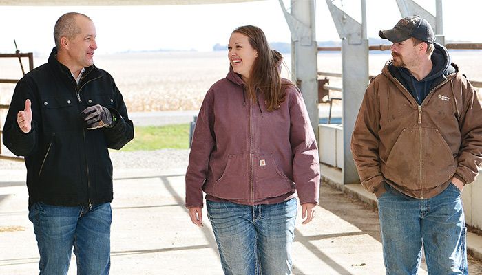 Iowa Secretary of Agriculture Mike Naig, left, visits with Laura and Aaron Cunningham about their Skyview Farms project. 