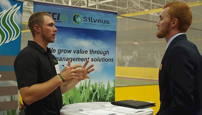 Logan Lyon, a sales agronomist at East Central Iowa Cooperative, based in the Hudson area, talks to Jordan Hagedon, a senior in ag business, during the ag career fair at Iowa State University. 
