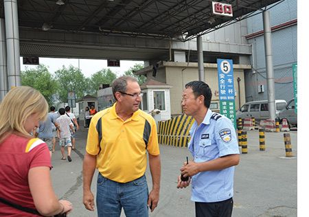 Farmer Larry Alliger shares a light moment with a Beijing security guard